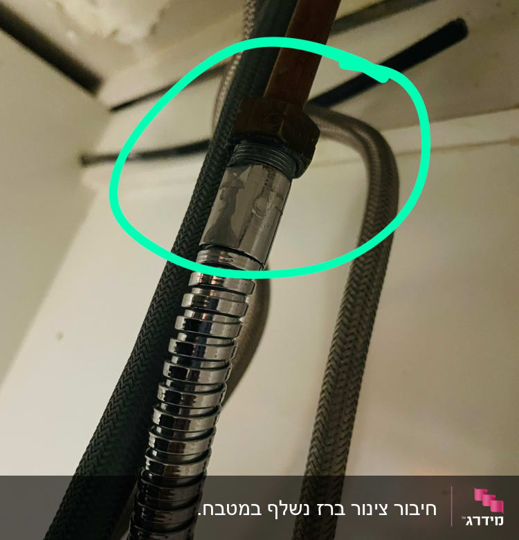 צינור מתכת עם חיבורי אינסטלציה מתחת לכיור